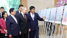 Thủ tướng Phạm Minh Chính và Tổng thống Putin xem trưng bày ảnh của TTXVN